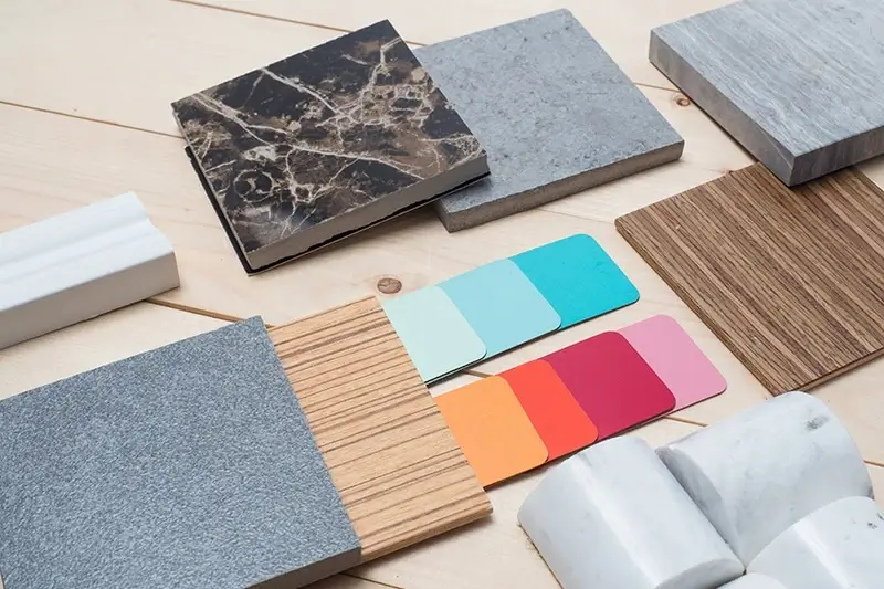 A collection of material samples like wood and fabric on a table.